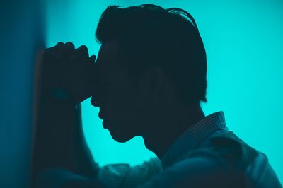 man leaning on wall